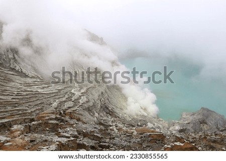 The landscape of high acid lakes and smoke from sulfur mines in Ijen Crate or 'Kawah Ijen', is located in Bondowoso, East Java, Indonesia. The site is officially a member of the Unesco Global Geopark. Royalty-Free Stock Photo #2330855565