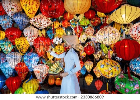 Asian woman wearing vietnam culture traditional and hoi an lanterns at Hoi An ancient town, Vietnam. Royalty-Free Stock Photo #2330866809