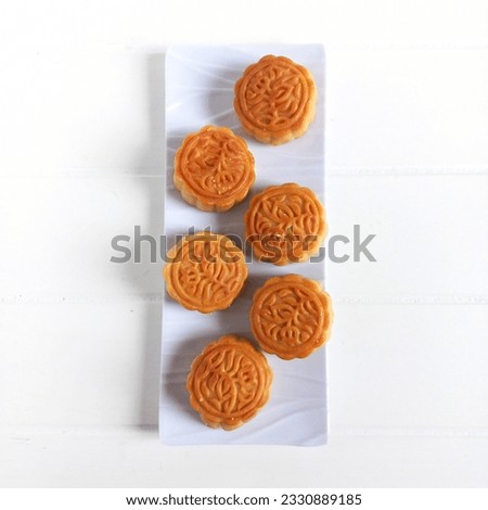Mooncake or Kue Bulan is traditional Chinese snack with is a mandatory dish at the annual Autumn  Festival Celebration. Served in ceramic plate. Isolated white background. Selective focus