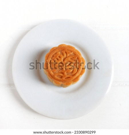 Mooncake or Kue Bulan is traditional Chinese snack with is a mandatory dish at the annual Autumn  Festival Celebration. Served in ceramic plate. Isolated white background. Selective focus