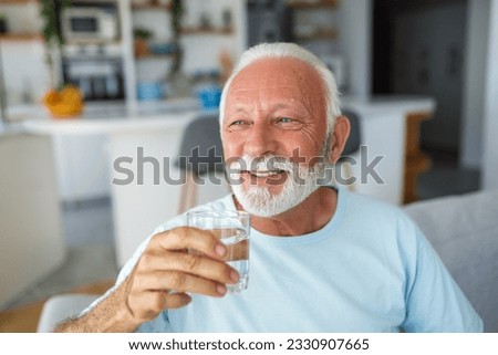 health-conscious senior man upholds his good lifestyle by savoring a glass of water. With each sip, he nourishes his body, exemplifying the significance of hydration and well-being in his golden years Royalty-Free Stock Photo #2330907665