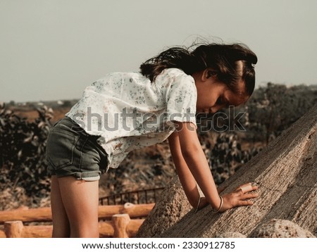 Awesome photo present filter effect on portrait sunset cute little girl image. Natural blur background and clear focus.Dark mode of adventure scenery. Different close up hand style wearing black. 