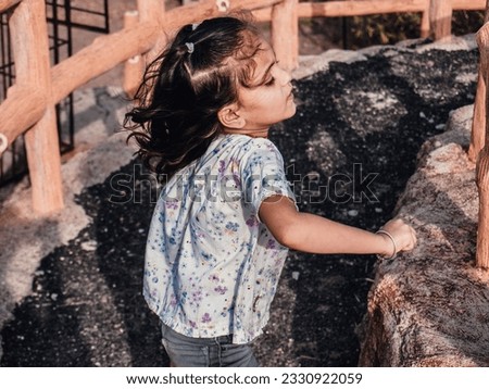 Present moody filter effect on camera portrait photo. Little kid girl playing outdoor in park. Healthy baby vintage photo of light and dark effect. Amazing style looks Glorious.  