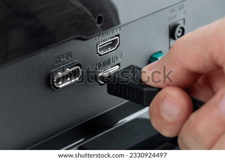 HDMI connector connected to the monitor, hand insert a HDMI cable Royalty-Free Stock Photo #2330924497