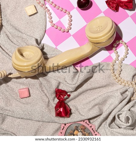 Telephone handset, chocolate cherries, candies, glitter fabric, creative girly mess, pink checkered pattern background. Retro nostalgia. 