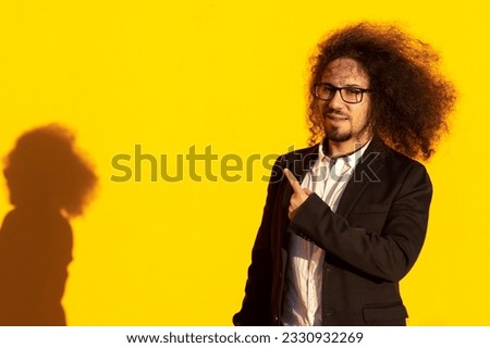 businessman point finger empty space banner wear glasses isolated on yellow color background