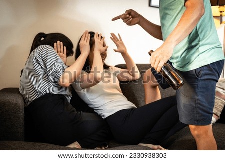 Drunken father threatening his family,bad habit,behavior from alcohol dependency,physical abuse,stop domestic violence,physically assaulted his wife,problem of drunkenness,addiction of alcoholic drink Royalty-Free Stock Photo #2330938303