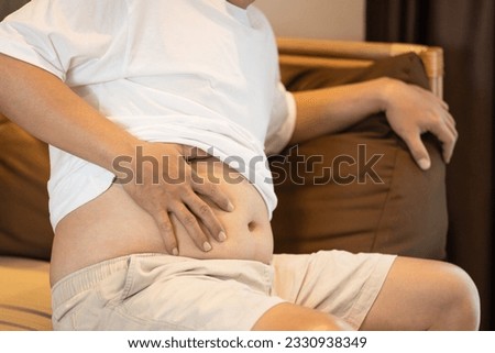 Middle aged man have flatulence,indigestion,pain and swelling in the stomach,abdominal discomfort,dyspepsia symptom,difficulty in digesting food,distended belly,digestive disorders or stomach ulcers Royalty-Free Stock Photo #2330938349