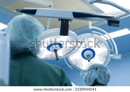 Surgery modern operating room with surgical lamp for emergency save lives.Medical team of surgeons working surgical intervention.Selective focus.