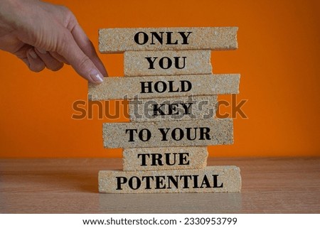 Your true potential symbol. Brick blocks with words Only you hold key to your true potential. Beautiful orange background, wooden table. Copy space. Business concept.