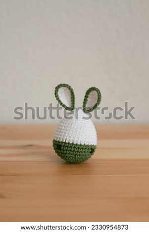 Handmade crochet easter bunny on wooden table and white background