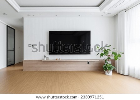 Blank modern flat screen TV hanging on wall in living room Royalty-Free Stock Photo #2330971251