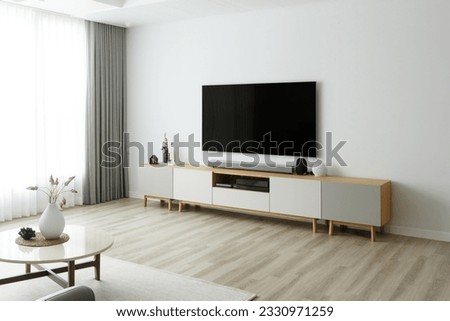 Blank modern flat screen TV hanging on wall in living room Royalty-Free Stock Photo #2330971259