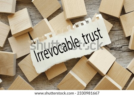 top view of wooden cubes. Irrevocable trust text on torn paper Royalty-Free Stock Photo #2330981667