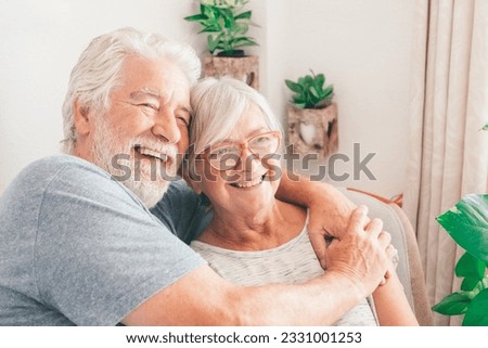Happy bonding loving middle aged senior retired couple sitting on sofa looking in distance, recollecting good memories or planning common future, enjoying peaceful moment together at home. Royalty-Free Stock Photo #2331001253