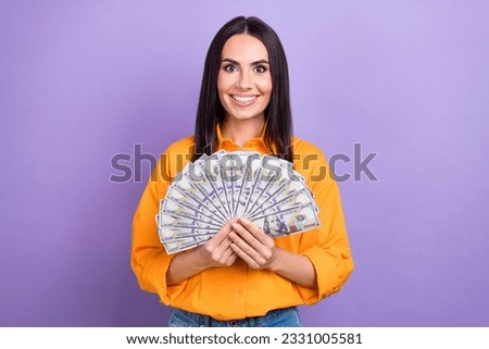 Photo of young businesswoman get extra salary hold money dollars banknotes winner jackpot casino isolated on violet color background