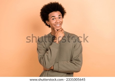 Portrait of minded positive person toothy smile arm touch chin contemplate isolated on beige color background