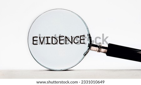 Looking through a magnifying glass at the word Evidence, a business concept. Magnifying glass on the background of columns of numbers. Royalty-Free Stock Photo #2331010649