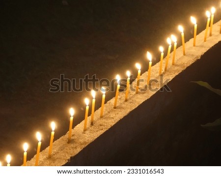 Picture of several candles lit at night, looking beautiful.