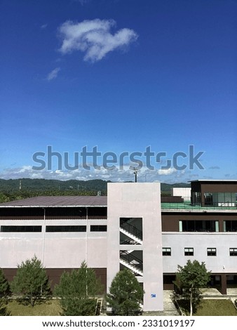 this building reminds me of anime school scene. trees, white building, sunny days, and rooftop are the best spot to chill after school.