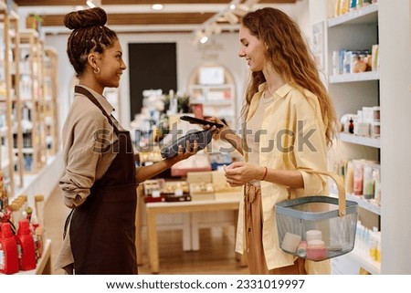 Customer paying for purchase with smartphone Royalty-Free Stock Photo #2331019997