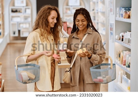 Girlfriends choosing cream together in the store