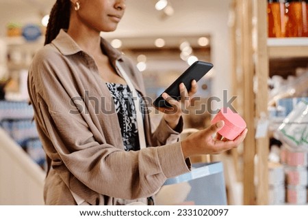 Woman making photo of cream on her smartphone