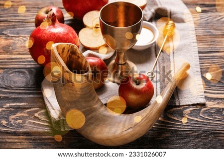 Shofar with fruits, honey and sacramental goblet for wine on wooden background. Rosh hashanah (Jewish New Year) celebration Royalty-Free Stock Photo #2331026007