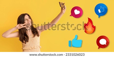 Young woman taking selfie and social network reactions on yellow background