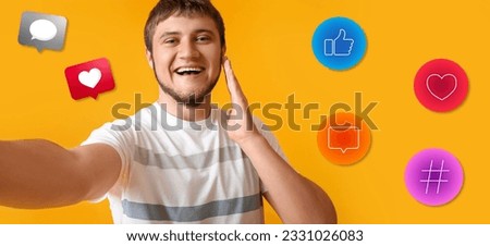 Happy young man taking selfie and social network icons on yellow background
