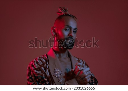 Retro wave or synth wave portrait young happy serious african-american man at studio. High Fashion male model in colorful bright neon lights posing. Royalty-Free Stock Photo #2331026655