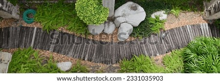 Top views of A row of wooden walkways in the garden with natural background at Thailand. Royalty-Free Stock Photo #2331035903