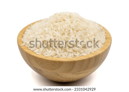 Raw rice isolated on white background. Uncooked dry rice in wooden bowl Royalty-Free Stock Photo #2331042929