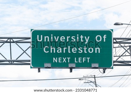 Charleston, USA University entrance direction sign in West Virginia capital city center for education isolated on highway against sky