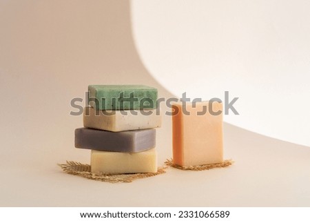 Pattern natural handmade soap of different sizes and colors. Brown background shadows of flowers from the sun. Cosmetic pedestal for product promotion Royalty-Free Stock Photo #2331066589