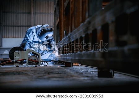 Industrial welder welding fabricated construction in factory, Welding process by Flux Core Welding, FCAW Royalty-Free Stock Photo #2331081953