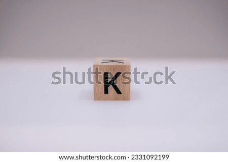 Wooden block written "K" with a white background