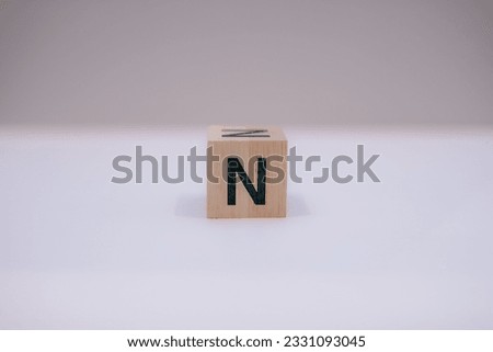 Wooden block written "N" with a white background