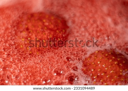 Pink foam for strawberry jam. Strawberries are boiled in a pot with sugar. The most delicious homemade strawberry jam. Soft selective focus on foam. An abstractly shaped picture with a partially shape