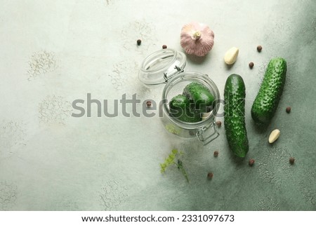 Jar with fresh cucumbers for preservation on grunge background