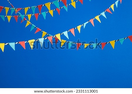 Colorful bunting flags paper on blue background with copy space. Concept of celebration, festival, party, happy birthday, design decoration.