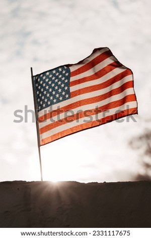 An American flag waving in the blue sky