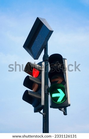 Close up of a traffic light on a clear blue sky with green arrow light up an red light. Yogyakarta, Indonesia.