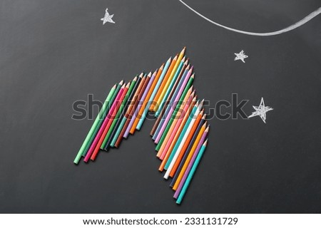 Pencils and drawn stars on black background