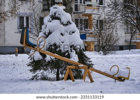 Playground covered with snow. swings, spinners and other play equipment