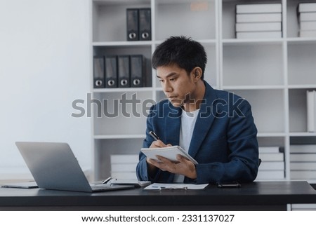Asian businessman working online with laptop at desk in office, Working businessman lifestyle concept. 