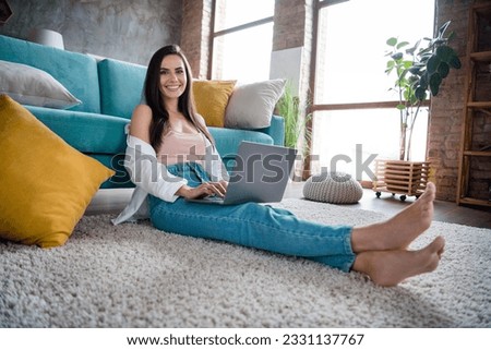 Photo of positive smart lady marketer sit carpet in shiny living room using netbook communicating in social media