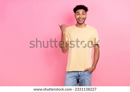 Photo of funky hipster man direct thumb finger empty space novelty wear yellow shirt jeans isolated pink color background