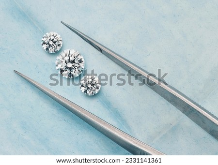 Three Stone Set of Diamonds - Trilogy Lab-Grown Diamond Set with Tweezers in Open Blue Parcel Royalty-Free Stock Photo #2331141361