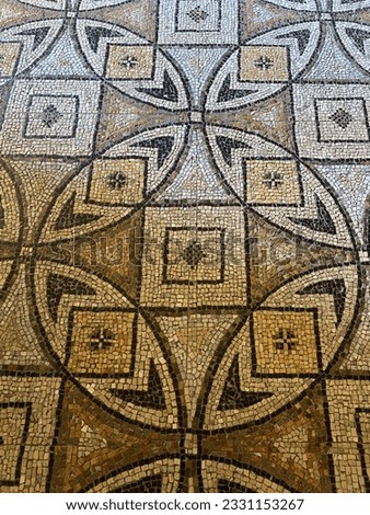 Mosaic handwork on the floor of a church in Ravena, Italy (Europe). Work made with pieces of stone in red, yellow, black, white, yellow and gray. Basilica de San Vitale. Pattern